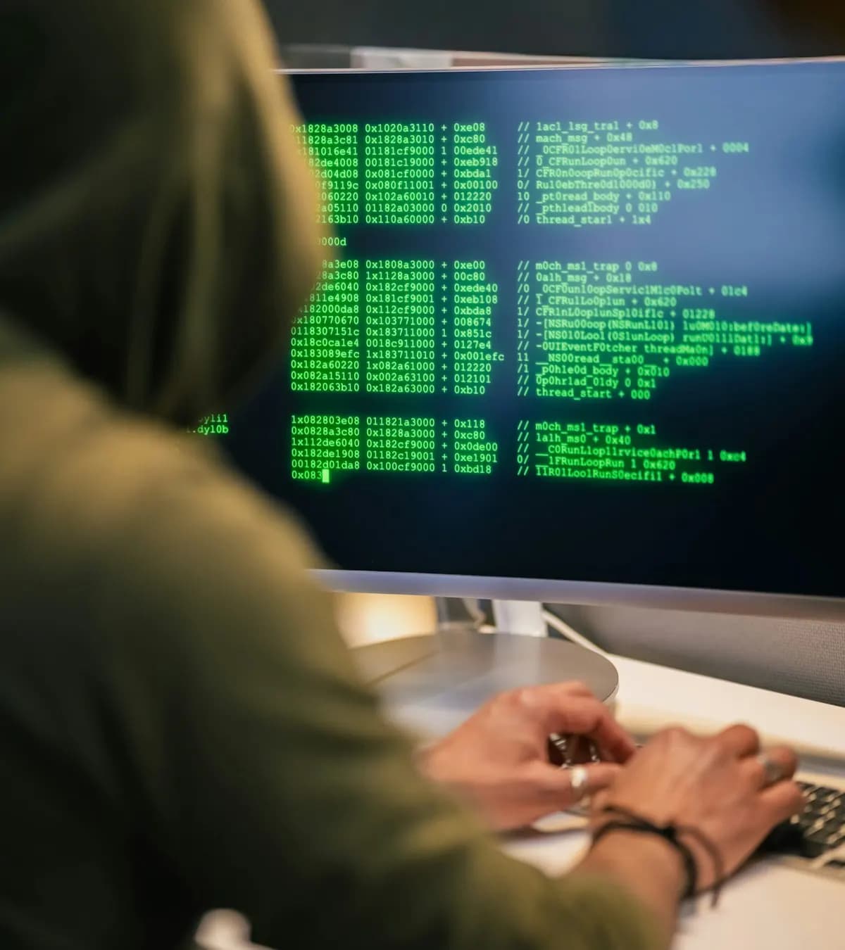 Personne encapuchonnée devant un terminal
