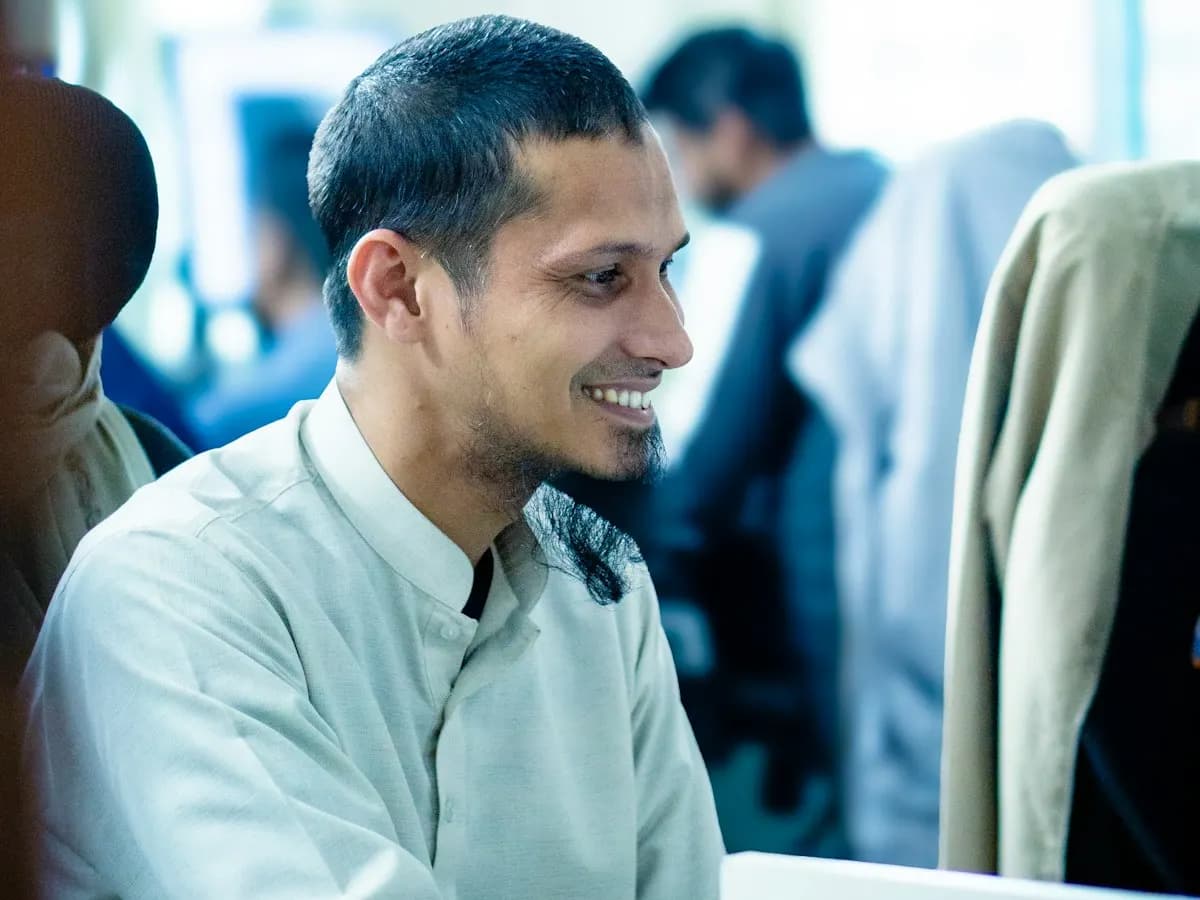 Salarié souriant à son poste dans un bureau partagé