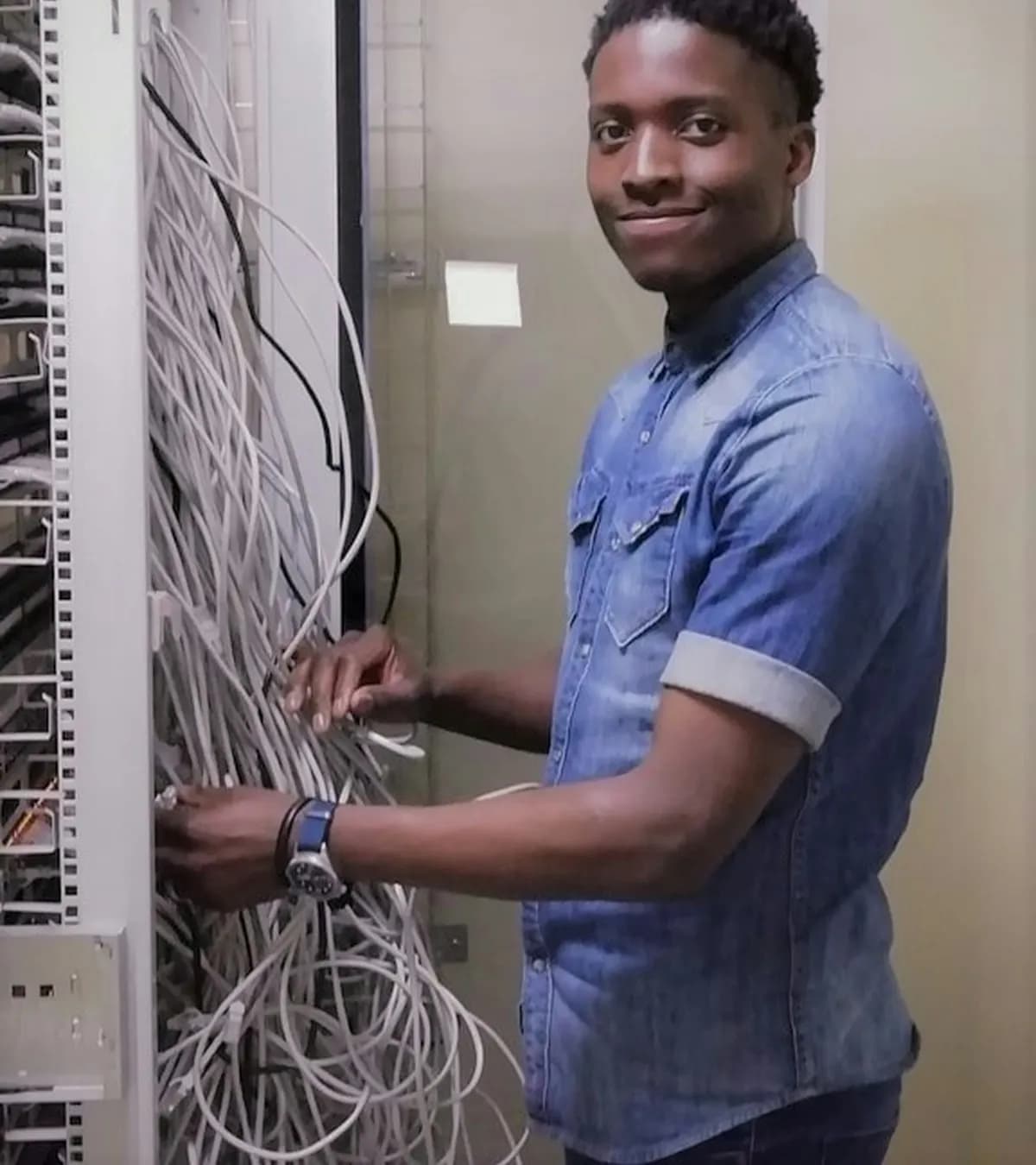 Technicien réseau souriant devant une baie